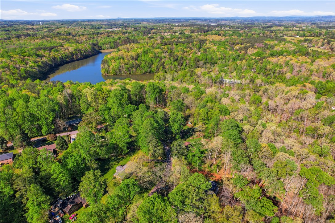 623 West Springwood Drive Seneca, SC 29672 - Photo 33 of 50 This tranquil aerial view reveals a verdant landscape embracing a serene lake under a clear sky.