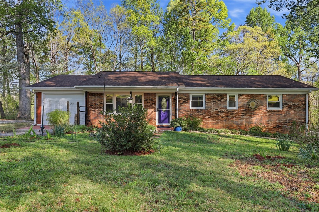 623 West Springwood Drive Seneca, SC 29672 - Photo 34 of 50 This charming brick ranch offers a cozy retreat with a vibrant front door and lush surrounding greenery.