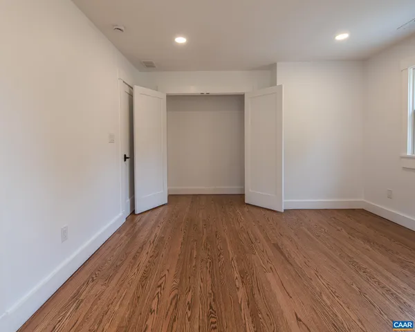 a bathroom with a granite countertop sink a toilet and mirror