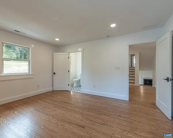 an empty room with wooden floor and window