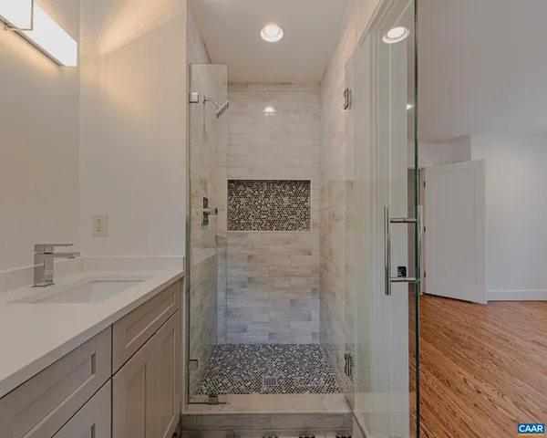 a view of a livingroom with a flat screen tv wooden floor and a window