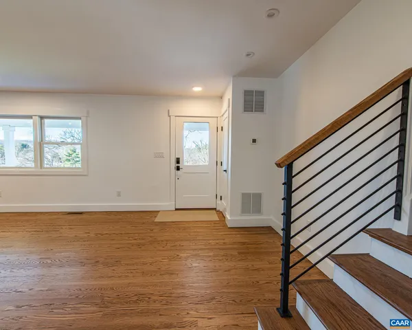 a kitchen with stainless steel appliances granite countertop a sink a stove and a wooden floor