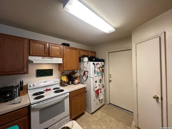 a kitchen with a refrigerator and a stove top oven
