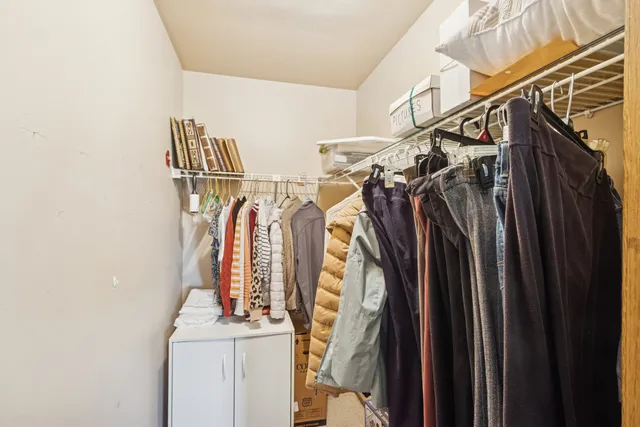 a view of walk in closet with clothes