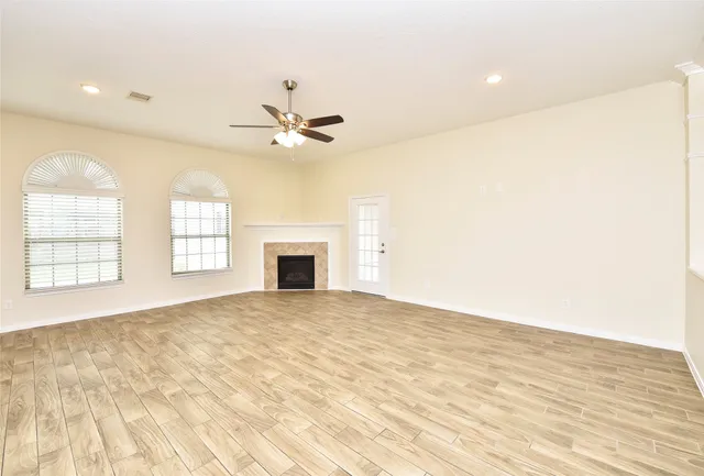 a view of an empty room with a fireplace and a window