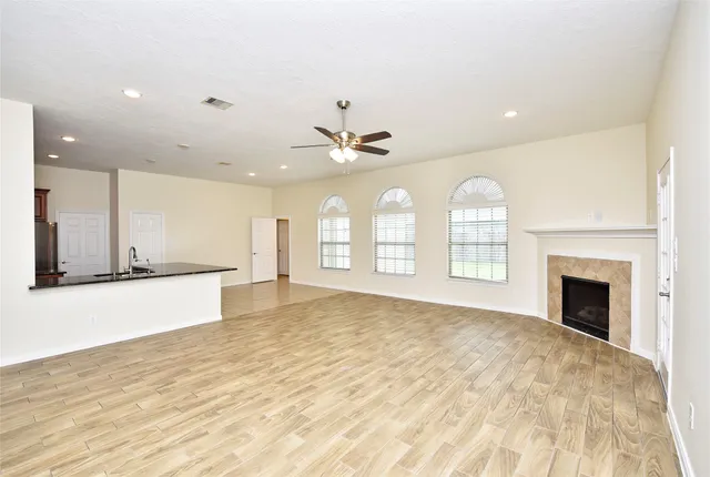 a view of an empty room with a kitchen and a window