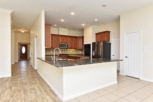 a large kitchen with stainless steel appliances granite countertop a large counter top and a stove