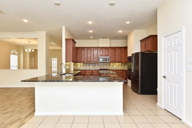 a kitchen with stainless steel appliances granite countertop a refrigerator and a sink