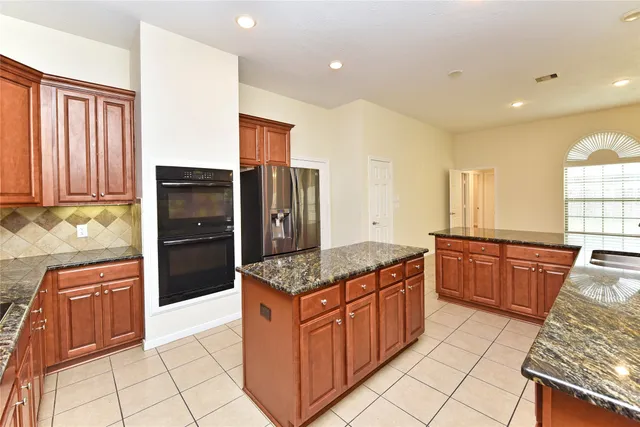 a kitchen with stainless steel appliances granite countertop a stove a refrigerator and a oven