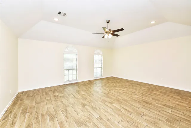 a view of empty room with wooden floor