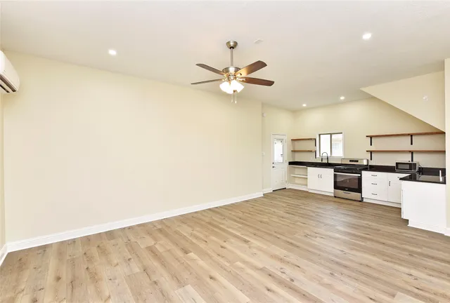 a kitchen with stainless steel appliances a stove and white cabinets