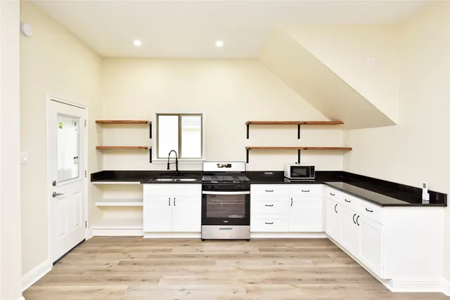 a kitchen with granite countertop white cabinets and white appliances