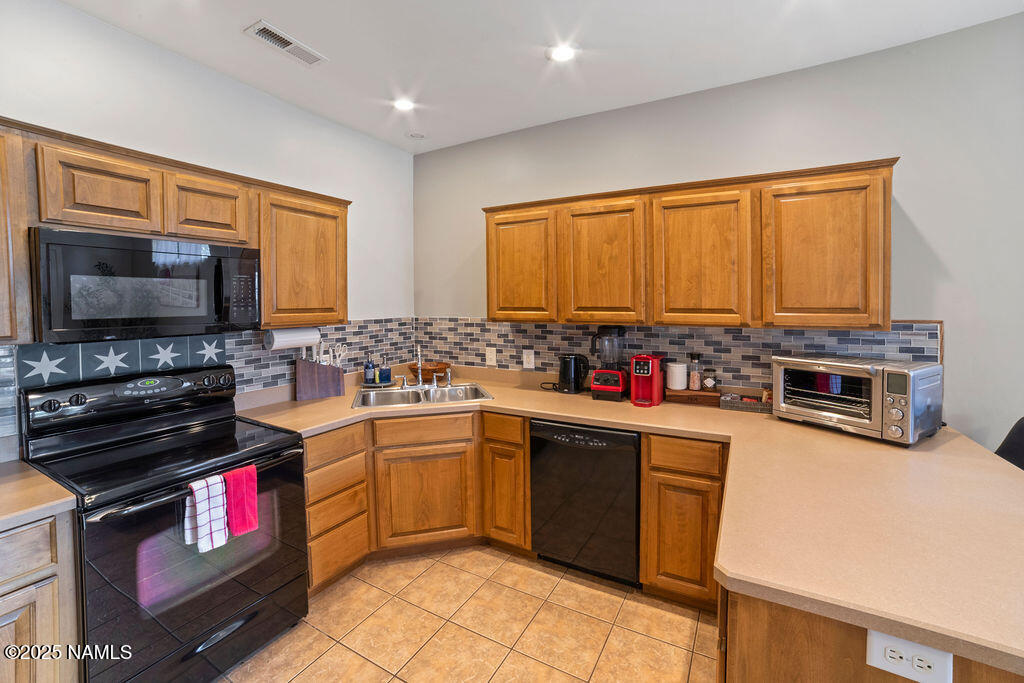 603 Brookline Loop Williams, AZ 86046 - Photo 26 of 57 a kitchen with stainless steel appliances a stove sink microwave and cabinets