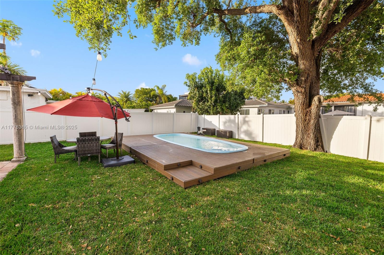 411 Southwest 22nd Road Miami, FL 33129 - Photo 21 of 25 a view of a backyard with a table and chairs under an umbrella