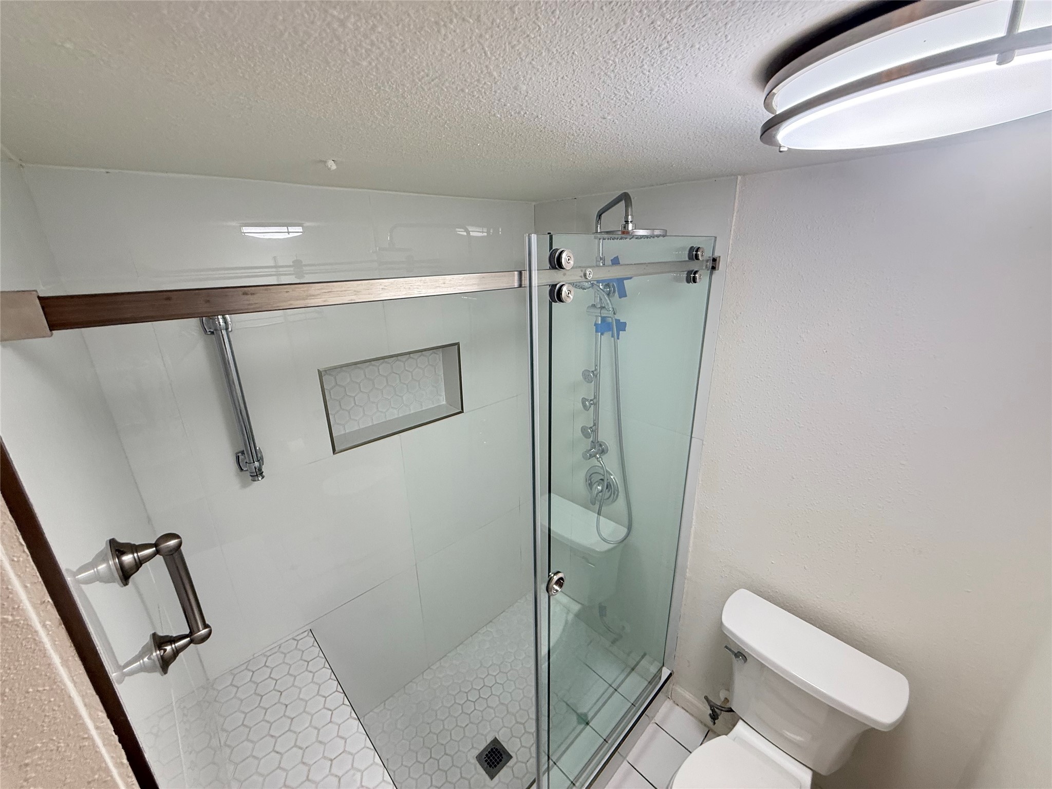 357 North Post Oak Lane, Unit 207 Houston, TX 77024 - Photo 24 of 25 a bathroom with a shower and toilet