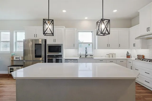 a large kitchen with a large counter top appliances and cabinets