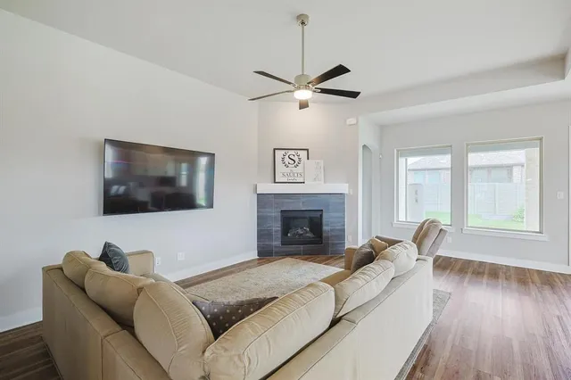 a living room with furniture kitchen area and a chandelier