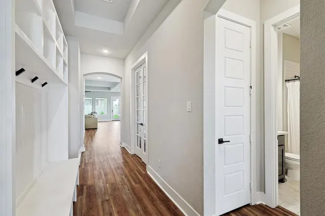 a view of a hallway with wooden floor and entryway
