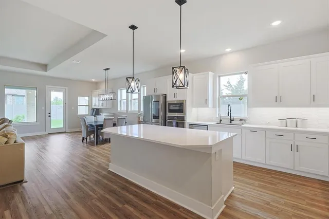 a large kitchen with sink cabinets and living room view