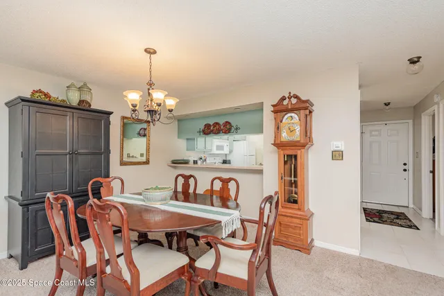 a view of a dining room with furniture a chandelier and wooden floor