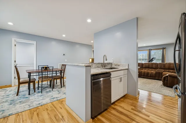 a living room with a couch and a dining table with wooden floor