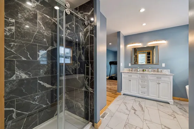 a bathroom with a sink mirror and a shower