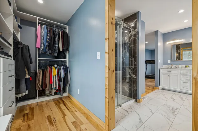 a view of a hallway with closet and wooden floor