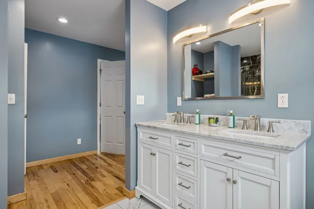 a en suite bathroom with a granite countertop sink and a mirror
