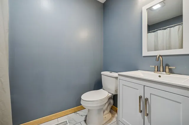 a bathroom with a toilet a sink and mirror