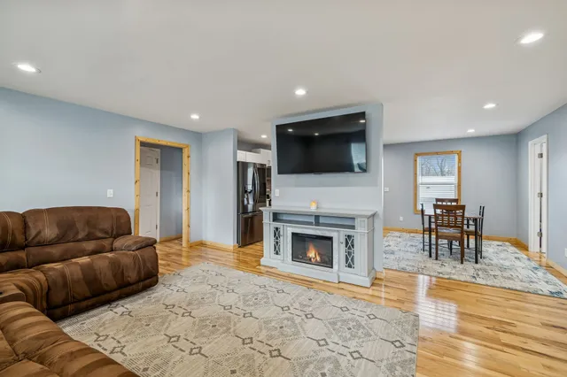 a living room with furniture a flat screen tv and a fireplace