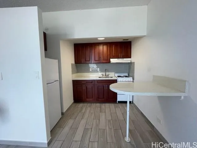 a kitchen with a sink a stove and cabinets