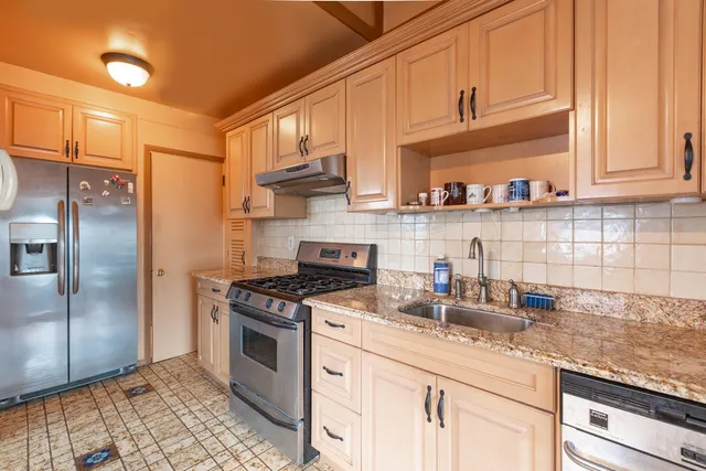 a kitchen with stainless steel appliances granite countertop a sink stove and refrigerator