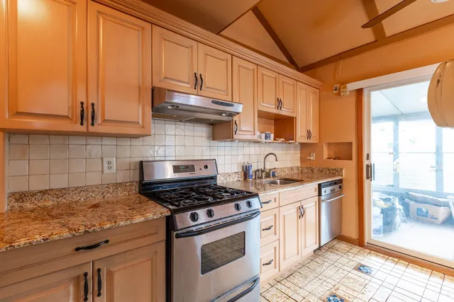a kitchen with stainless steel appliances granite countertop a stove a sink and a microwave