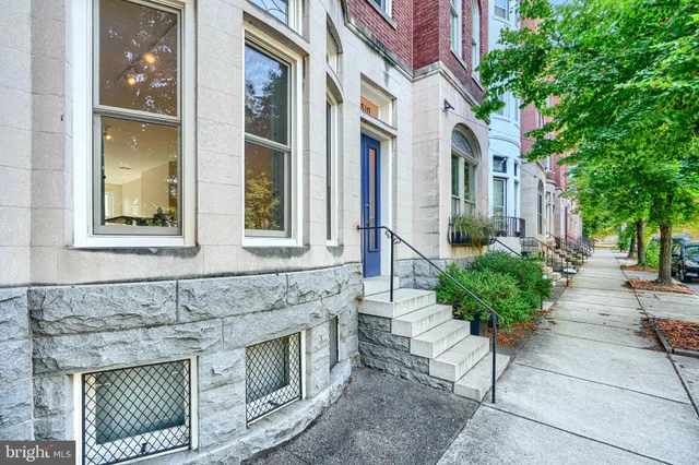 a brick house with a large windows and a potted plant