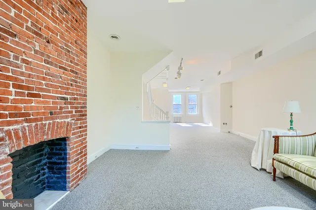 a living room with furniture a fireplace and a chandelier