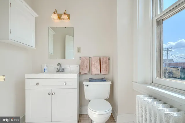 a bathroom with a granite countertop toilet sink and mirror