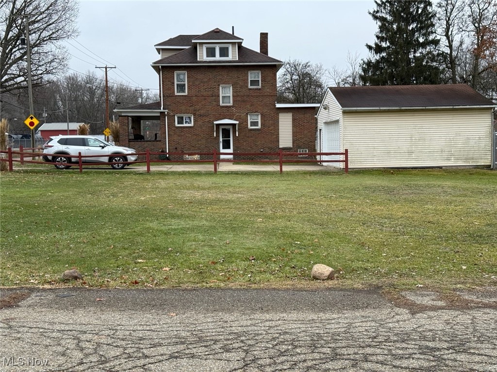1311 Warner Road Southeast Canton, OH 44707 - Photo 14 of 14 Rear view of house featuring a chimney, a lawn, an outbuilding, and brick siding