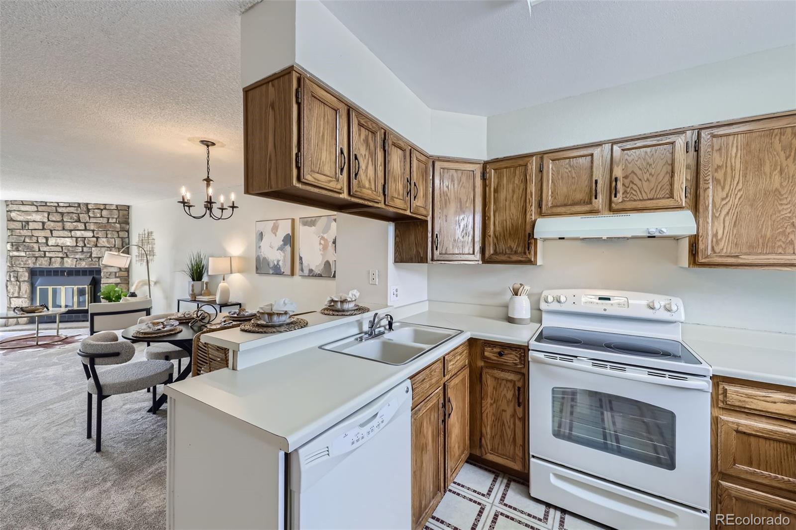 1811 South Quebec Way, Unit 244 Denver, CO 80231 - Photo 11 of 25 a kitchen with a stove a sink and cabinets