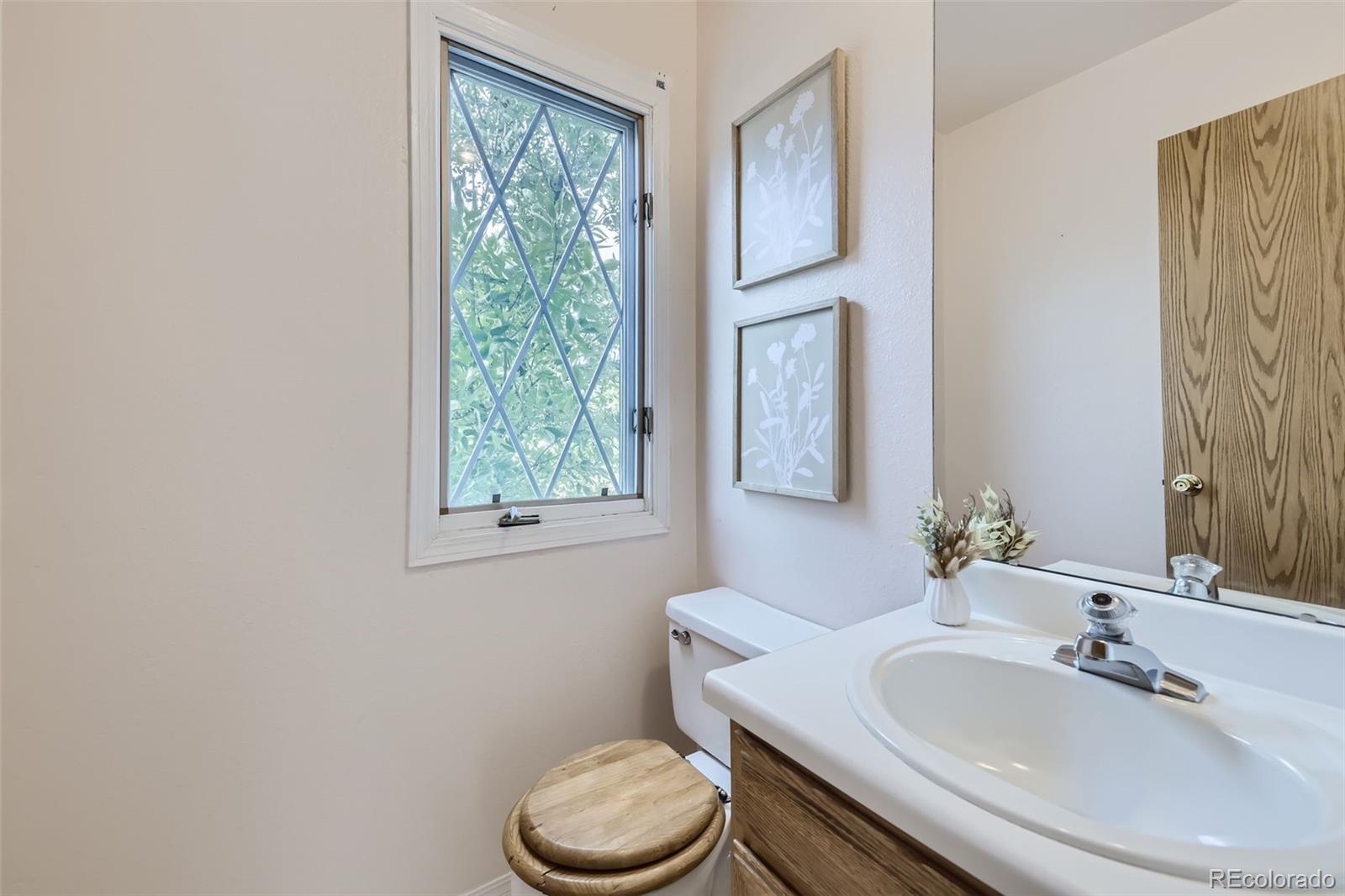 1811 South Quebec Way, Unit 244 Denver, CO 80231 - Photo 14 of 25 a bathroom with a toilet sink and mirror