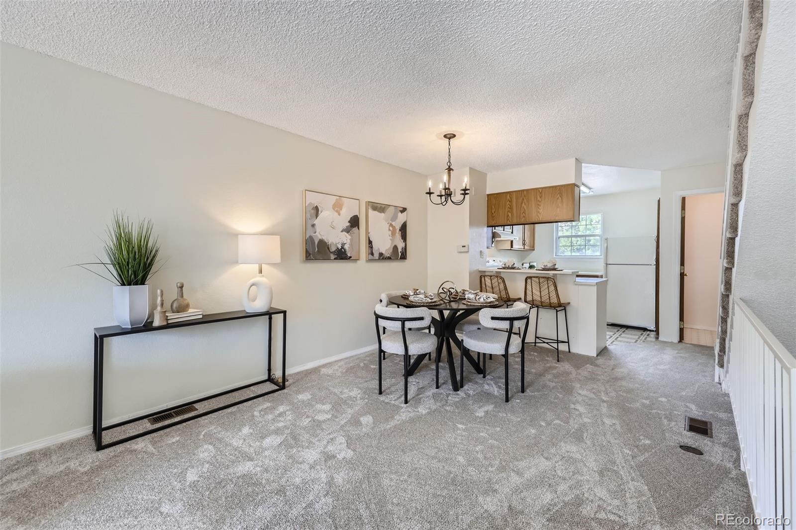 1811 South Quebec Way, Unit 244 Denver, CO 80231 - Photo 7 of 25 a view of a dining room with furniture and a chandelier