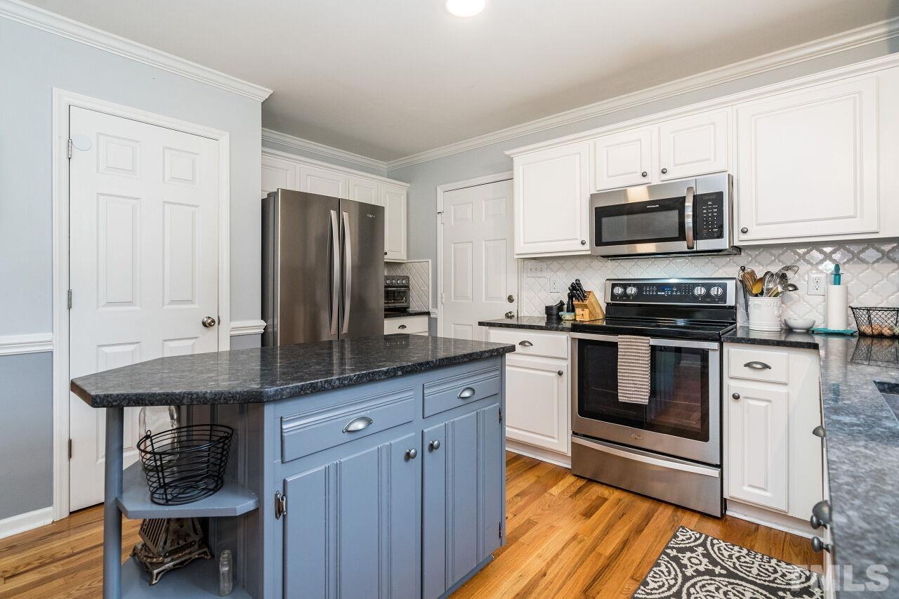 1037 Red Brick Road Garner, NC 27529 - Photo 12 of 33 a kitchen with stainless steel appliances granite countertop a stove top oven a sink and dishwasher a refrigerator with wooden floor