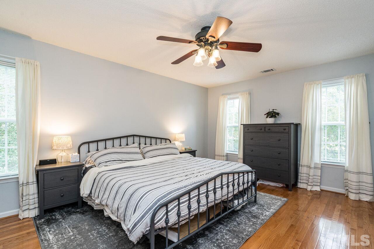 1037 Red Brick Road Garner, NC 27529 - Photo 14 of 33 a bedroom with a bed and a chandelier