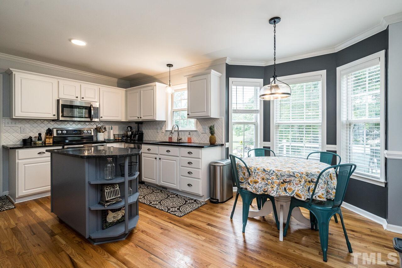 1037 Red Brick Road Garner, NC 27529 - Photo 9 of 33 a kitchen with a table chairs appliances and cabinets