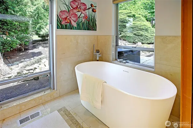a white bath tub sitting in a bathroom next to a window