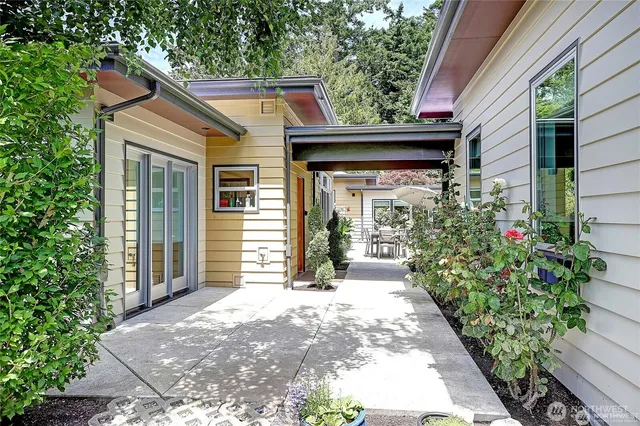 a view of a house with a small yard plants and large tree