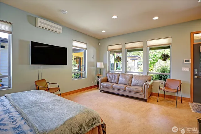 a bedroom with a bed a couch and a flat screen tv