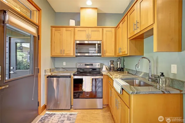 a kitchen with stainless steel appliances granite countertop a sink stove and refrigerator