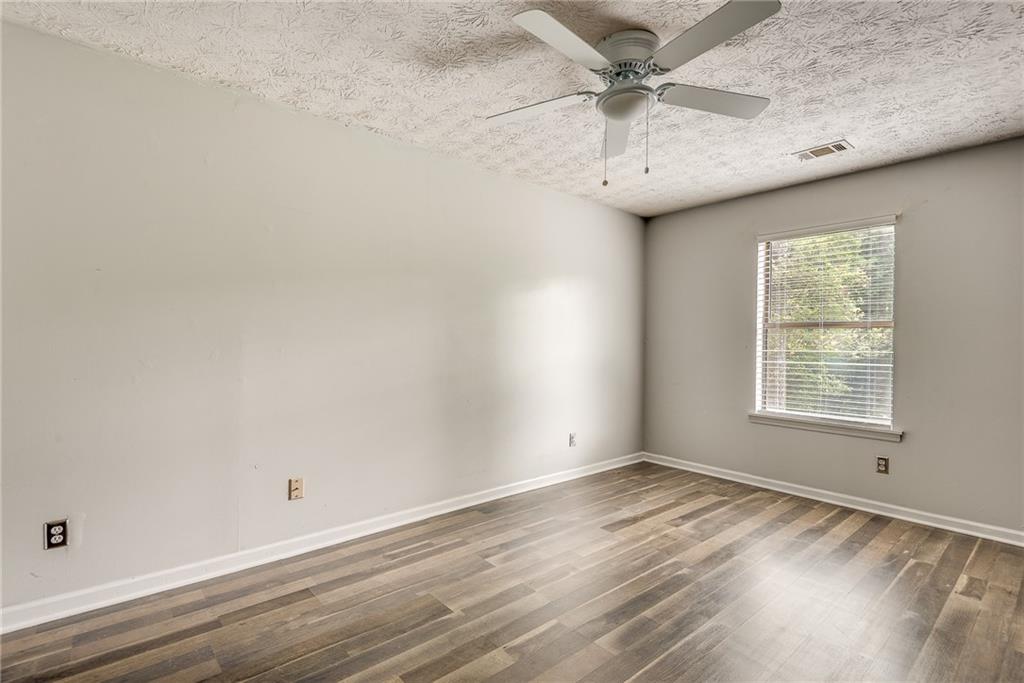 5611 Whittondale Road Lithonia, GA 30058 - Photo 22 of 34 an empty room with a window and a ceiling fan