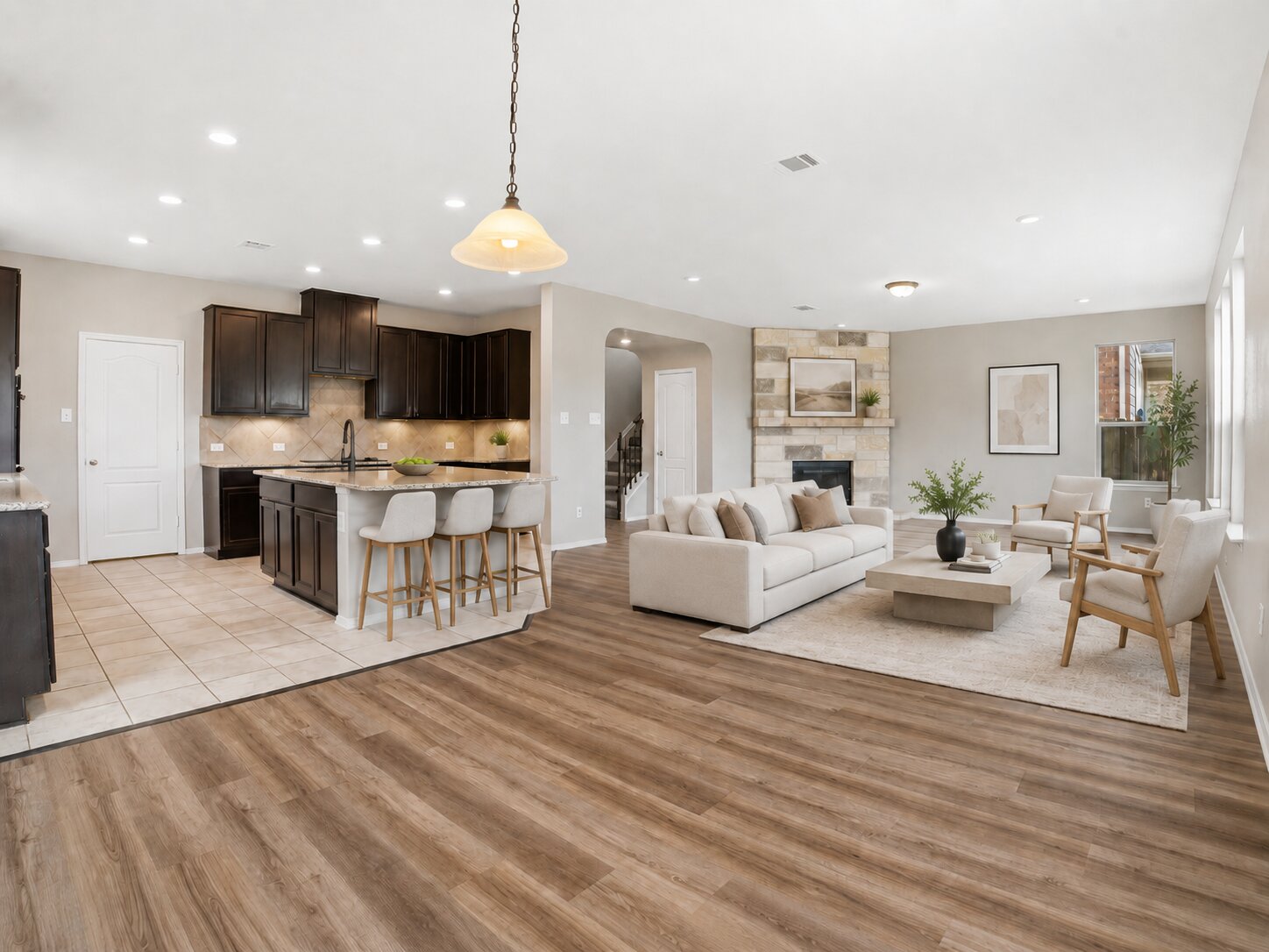 670 Landon Samuel Loop Pflugerville, TX 78660 - Photo 2 of 22 Open-concept living space featuring wood-finish flooring, a stone-clad fireplace, and recessed lighting
