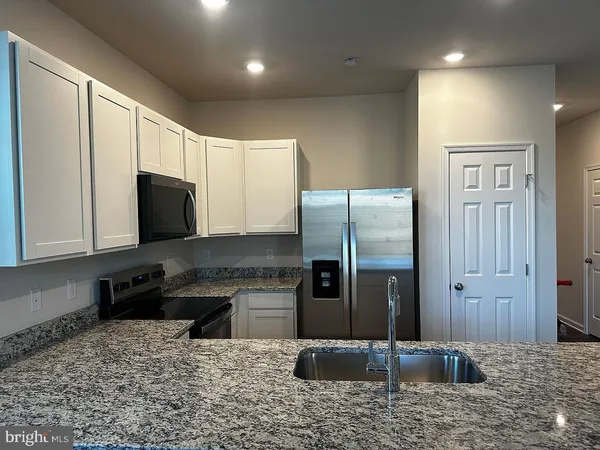 a kitchen with a refrigerator sink and cabinets